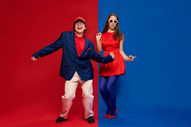 Renkli stüdyoda dans eden çift eski moda kıyafetler giyip neşe ve bağlarını ifade ediyorlar. İnsan duyguları, ilişkisi, yaşam tarzı kavramı