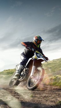 Bisiklet sürücüsünün dikey görüntüsü tozlu çimenli yolda hızla ilerlerken güneşli manzaralı. Yol dışı seyahat. Motor sporu, spor, hız, seyahat. 3 boyutlu arkaplan oluşturma. Birleşik resim