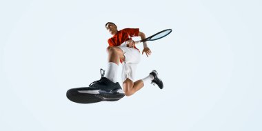 Genç adamın alt tarafı, tenis raketiyle beyaz stüdyo arka planına poz veren bir tenisçi. Spor, oyun, turnuva, pratik, gençlik kavramı