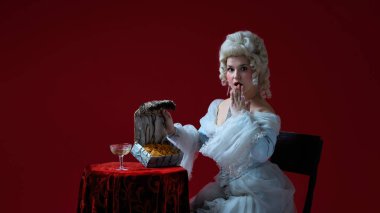 Gizli hazine. Tarihi rokoko 'daki kadın karakter süslü göğüslerinde çipler keşfediyor, şaşırmış bir ifade. Dönem, güzellik, tarih, sanat, yaratıcılık, fantezi karşılaştırması.