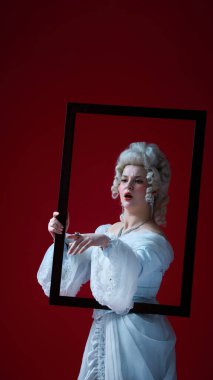 Çerçeve kırılıyor. Barok kadın portresi çerçevede hareketli, dinamik duruş ve koyu kırmızı arka planda dramatik enerji. Dönem, güzellik, tarih, sanat, yaratıcılık karşılaştırması.