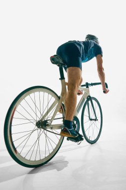 İnsanın arka planı, hareket halindeki bisikletçi, antrenman, azimle bisiklete binme ve beyaz arka plana odaklanma. Spor anlayışı, rekabet, aktif yaşam tarzı, dayanıklılık