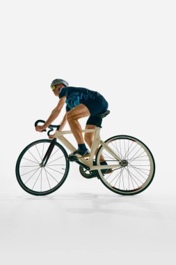 Düşük açılı insan görüntüsü, tam donanımlı profesyonel bisikletçi, bisiklet sürme, beyaz arka planda izole edilmiş eğitim. Spor anlayışı, rekabet, aktif yaşam tarzı, dayanıklılık