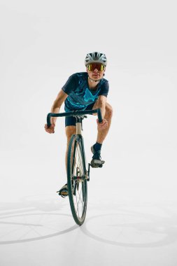 Tam donanımlı genç bir adam, beyaz arka planda izole edilmiş bisiklet süren bir bisikletçi. Spor anlayışı, rekabet, aktif yaşam tarzı, dayanıklılık
