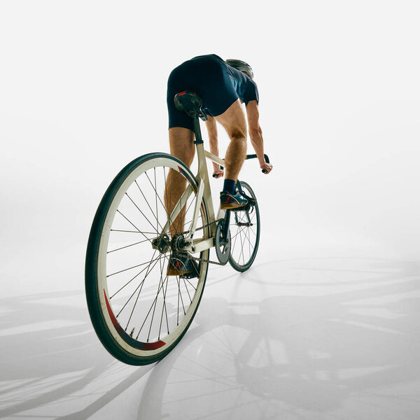 Обратный вид человека, велосипедист в движении, тренировки, езда на велосипеде с решимостью и фокус изолированы на белом фоне. Концепция спорта, соревнования, активный образ жизни, выносливость