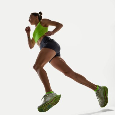 Parlak yeşil bluzlu güçlü bir kadın stüdyo arka planında, düşük açılı bir görüntü yakalamış. Spor kavramı, rekabet, aktif yaşam tarzı, eğitim, fitness, güç.