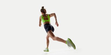 Stüdyoda parlak ışıkla ileri doğru koşan sportif bir kadının arka plan görüntüsü. Spor, rekabet, aktif yaşam tarzı, hız, kararlılık, hareket kavramı.