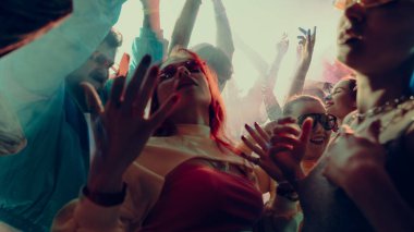 İnsanların enerjik bir şekilde dans ettiği canlı bir parti sahnesi. Konser, parti, müzik, ritim kavramı.