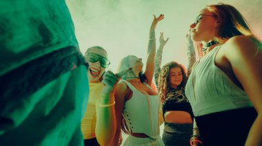 Canlı bir partide canlı ışıklandırmayla dans eden bir grup insan. Gece hayatı kavramı, parti, gençlik, yaz, şenlik, kutlama