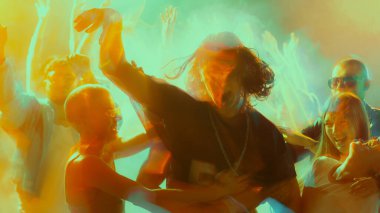 Enerjik kalabalık hareketli, renkli bir partide dinamik ışıklandırmayla dans ediyor. Gece hayatı kavramı, parti, gençlik, yaz, şenlik, kutlama