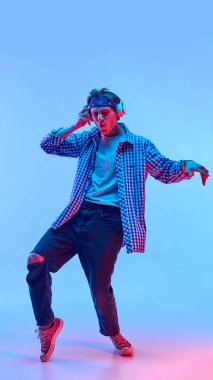 Bir bacağı havada, gözleri kapalı dans eden genç bir adam neon ışıkta müzik dinliyormuş gibi arka planda rahat bir neşe gösteriyordu. Özgürlük kavramı, insani duygular, tarz. Ad