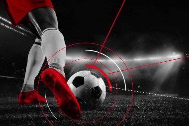 Kırmızı kramponların yakın çekimleri stadyum ışıkları altında radyal kırmızı takip hatlarıyla futbol topuna çarpıyor. Kavramsal sanat eserleri. Profesyonel spor kavramı, yarışma maçı, oyunlar, etkinlikler