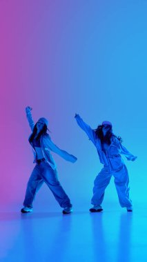 Kot giymiş sokak dansçıları, arka planda mavi ve morumsu ışık altında hip hop performansı için ısınıyorlar. Genç sanatçılar. Müzik, hazırlık, ritim ve enerji kavramı.