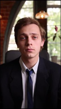 Kendine güvenen, şık giyinmiş, dizüstü bilgisayarla çalışan genç bir adam modern ofise odaklanmış görünüyor. İş anlayışı, nüfuz, serbest çalışma, yatırımcılık. ad