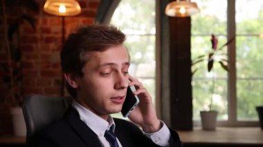 Sivri takım elbiseli bir işadamı telefonda ciddi bir yüzle konuşuyor, ofis penceresinin önünde oturuyor, yoğun sohbete odaklanıyor ya da önemli kararlar alıyor. İş anlayışı, iletişim