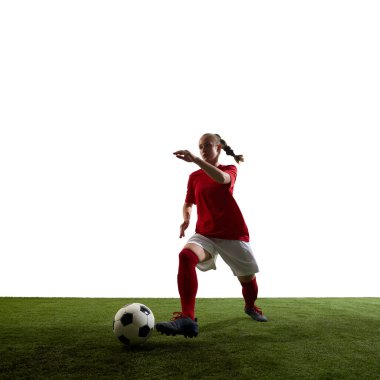 Top süren bayan futbolcu, yeşil çimenli sahada beyaz arka planda gol atmaya hazır. Spor, eğitim, hazırlık, güç, rekabet, kontrol kavramı