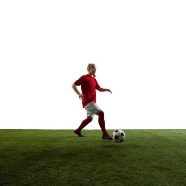 Beyazların arka planına karşı yeşil çimenli oyun parkında kararlılık gösteren maçta ileri doğru top süren odaklanmış genç bir kadın. Spor, oyun, kadın futbolu, hız, kontrol kavramı