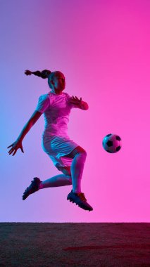 Dişi sporcunun dinamik fotoğrafı, yoğun bir bakışla orta sıçrayışta çekildi. Pembe-mavi ışıklar altında rakibi püskürtmeye ve gol atmaya hazır. Spor anlayışı, güç, esneklik, eylem