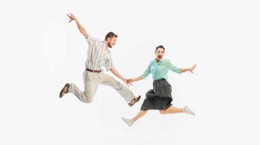 Swing dansı stilinde geçmişe dönük bir sıçrama beyaz bir arka plana doğru havada kaydedilir. Klasik dans canlandırması ve zamansız ritim kavramı..