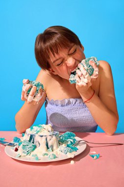 Kızgın kadın saldırganca krema ile jöleli tatlıyı eziyor ve ısırıyor. Gıda öfkesi kavramı, anlamlı pazarlama, duygusal zıtlıklar, cesur atıştırmalık kültürü, gerçeküstü görseller..