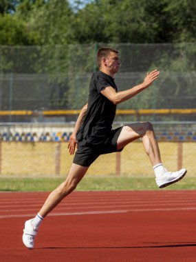 Atlet, antrenman sırasında kırmızı yolda koşarken koşuyor. Sırıkla atlamada çalışma aşaması kavramı, hız artışı, dinamik hareket, sürat gücü