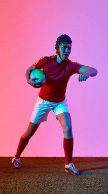 Rugby 'li kadın sporcu, dinamik bir şekilde gradyan zemine karşı poz veriyor. Eğitim modu kavramı, yumruğa hazır duruş, güven ve denge