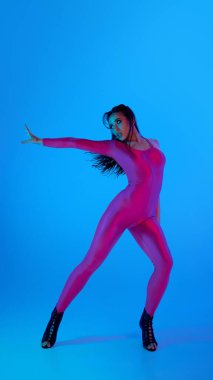 Canlı pembe elbiseli dansçı mavi arka planda poz veriyor. Dans markası kavramı, nüfuzlu kimlik tasarımı, performans alanları için tanıtım.