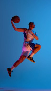 Sporcu, canlı gradyan ışıklandırma altında basketbol sıçrayışı yapıyor. Aydınlatılmış kontrol kavramı, hareket halindeki vücut dili, dikey eylem ve yaratıcı basketbol posterleri..