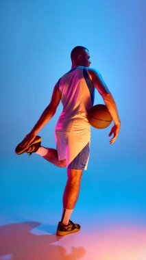 Basketbol atleti, parlak neon ışıklarının altında topla poz veriyor. Çıkış enerjisi kavramı, sinematik yürüyüş, dinamik kas duruşu ve şık atlet markalaşma kampanyaları..