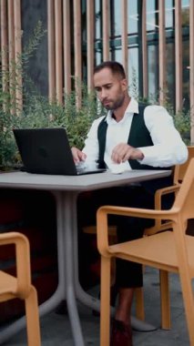 Adam dizüstü bilgisayarı kapatıyor, temiz hava soluyor, çalışma alanında dinleniyor. Uzak iş rutini kavramı, özenli iş hayatı dengesi, rahatlama ve görev sonrası doğal ortamdaki yansıma.