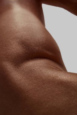 Yumuşak ışık altında erkek vücudunun yan kıvrımlarına yakın çekim. Vücut kimliği kavramı, erkek masaj tanıtımı, modern erkeklik ve duygusal farkındalık..