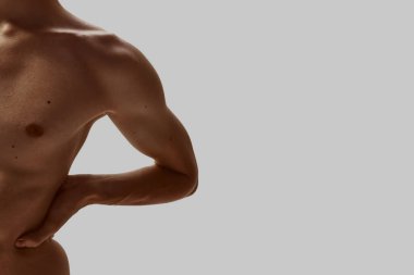 Erkek üst gövdesi, elleri belinin altında rahat bir şekilde dinleniyor. Osteopati, rehabilitasyon, sağlık, erkek sağlığı ve vücut terapisi kavramı.