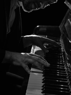 Erkek piyanistlerin elleri dramatik bir ışıkta piyano tuşlarına basıyor. Müzik festivali posterleri, yayın servisi kapakları, ses markaları kampanyaları, farkındalık ve piyano dersleri kavramı.