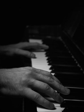Erkek ellerinin düşük ışıkta piyano tuşları çalması ve duygusal temasta bulunması. Yayın kapakları, ses markası reklamları, piyano eğitimi, farkındalık, müzik blogları kavramı.