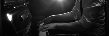 Sahne ışıkları altında piyano çalan siyah-beyaz piyanist elleri. Müzik festivali posterleri, yayın kapakları, farkındalık içeriği, piyano dersleri, müzik blogları. Pankart