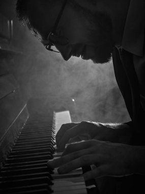 Siyah-beyaz duygusal ifadeyle piyano çalan adama yaklaş. Sanatsal performans kavramı, müzik reklamı, olay markalaşması, kültürel hikaye anlatımı ve müzisyen portreleri..