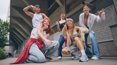 Neşeli sokak dansçıları, gösteriden sonra kahkahalar ve özgüvenle poz veriyorlar. Gençlik kültürü, yaşam tarzı, sosyal medya markalaşması, dans ve müzik yaratıcılığı ve tanıtımı kavramı.