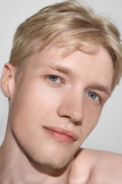 Yumuşak bakışlı ve parlak tenli genç bir adamın portresi. Cilt bakım, doğal güzellik, kozmetik markalaşma, sağlık yaşam tarzı ve kişisel bakım kavramı.