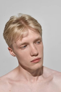 Düşünceli bir ifade ve doğal deri dokusuyla genç bir adam portresi. Özgünlük kavramı, cilt bakımı, sağlık kampanyaları, erkeklerin güzellik markalaşması ve yaşam tarzı pazarlaması..