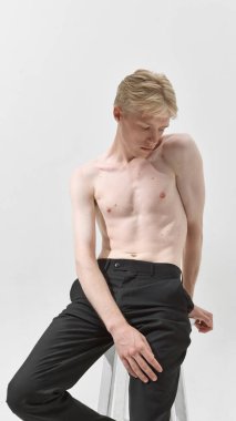 Belirli duruşu ve temiz cildi olan tişörtsüz bir erkek model. Vücut güveni, sağlık yaşam tarzı, tımar, cilt bakımı endüstrisi ve modern moda estetiği kavramı.