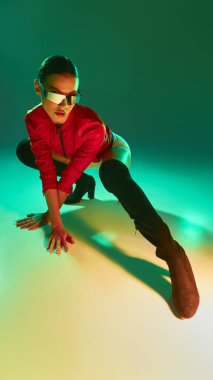 Kırmızı ceketli dinamik bir kadın ve çarpıcı yeşil ışıkla çömelmiş fütüristik gölgeler. Moda, şehir kimliği, dijital sanat, güç, hareket ve bireysellik kavramı.