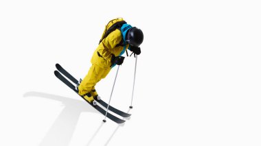 Male skier leaning forward with poles in motion isolated on white background. Concept of alpine training visuals, professional ski technique ads, winter sport branding and lifestyle campaigns.