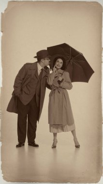 Playful romantic couple with umbrella retro vintage style. Concept of love, lifestyle, nostalgia, fashion, sepia effect, and retro storytelling advertising.