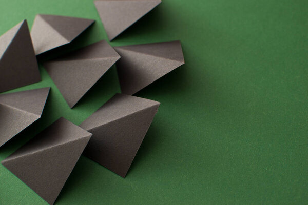 Black triangle shapes on green background with copy space