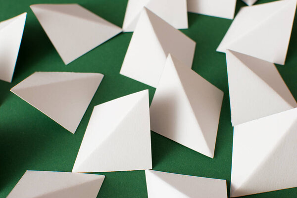 White geometric triangle shapes on green background, close up