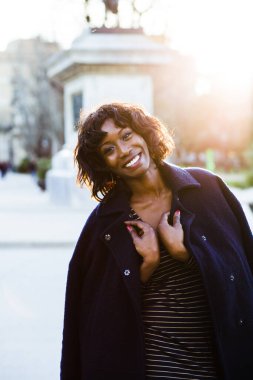 Arka planda günbatımı olan genç bir mankenin şehirde dolaşması..