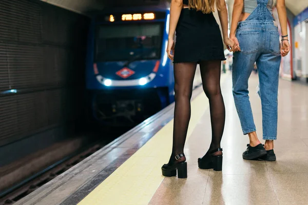 两女手牵手 乘地铁到达车站 — 图库照片