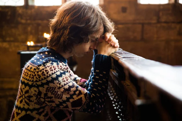 教会の中で祈るクリスチャンの少年 — ストック写真
