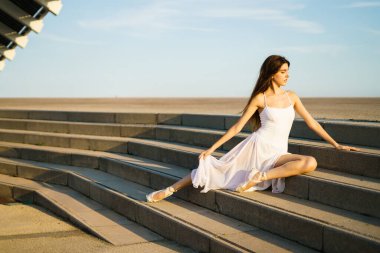 Yetişkin bir kadın gün batımında tek başına sokaklarda dans ediyor. .