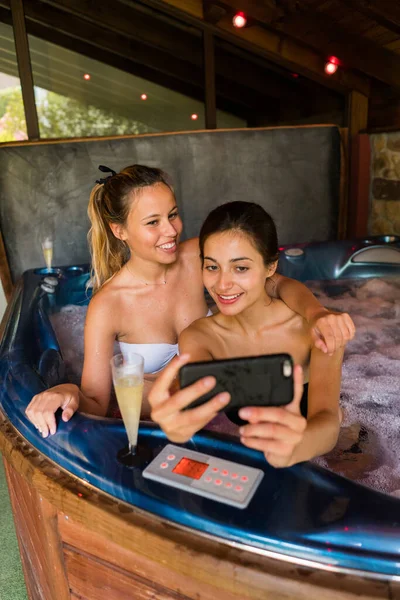 Couple Female Sitting Hot Tub Taking Selfie Smartphone Stock Image